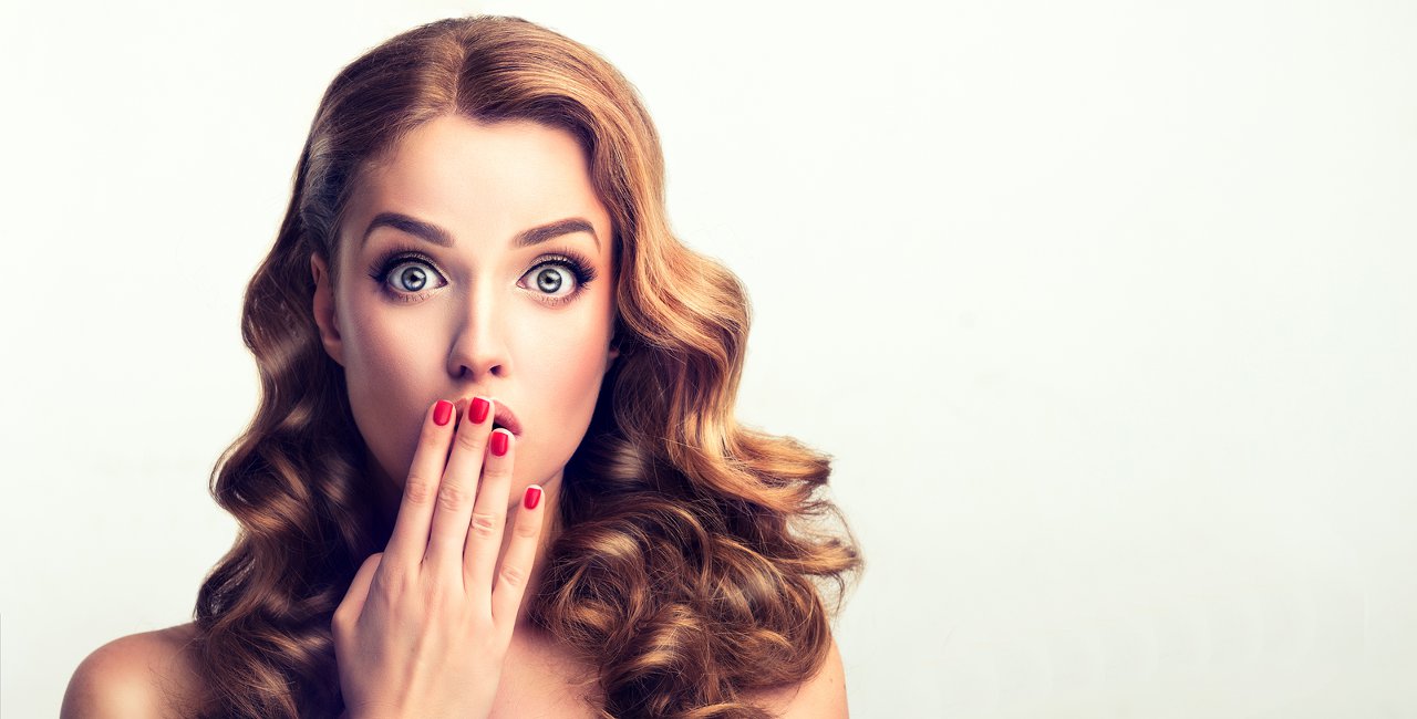 Woman with hand up to mouth looking surprised