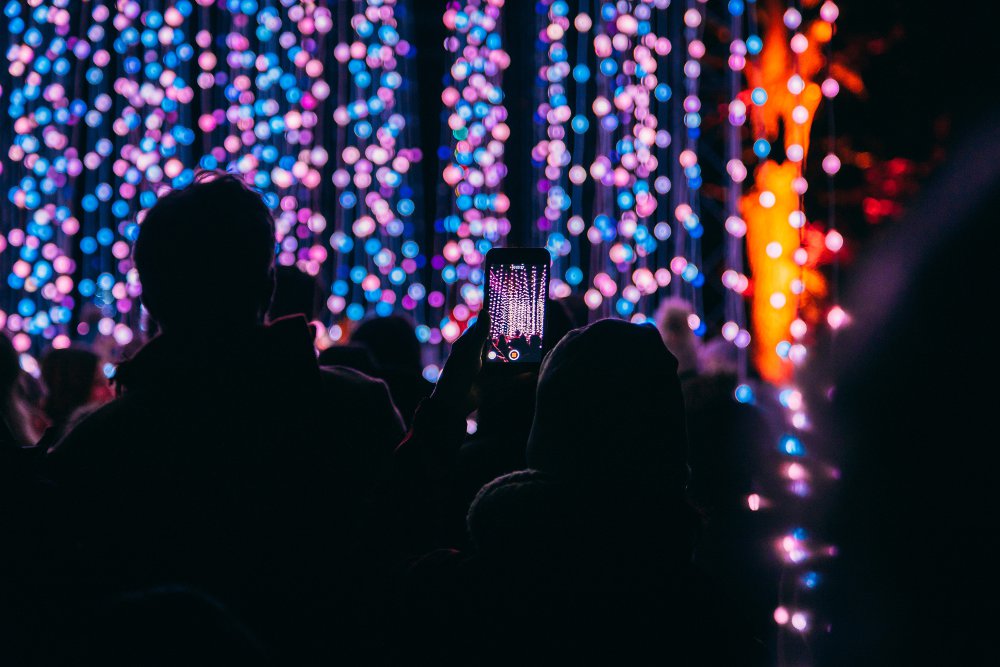 People in crowd looking at coloured lights on stage