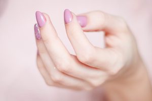 Close up of female hand with pink nail polish