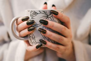 Woman with acrylic nails holding cup